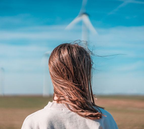 young-woman-wind-turbine Young woman and renewable energy wind turbine